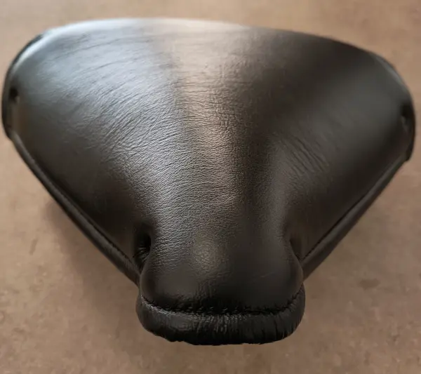 Nově potažené kožené sedlo motocyklu v černé barvě, precizní čalounické zpracování.