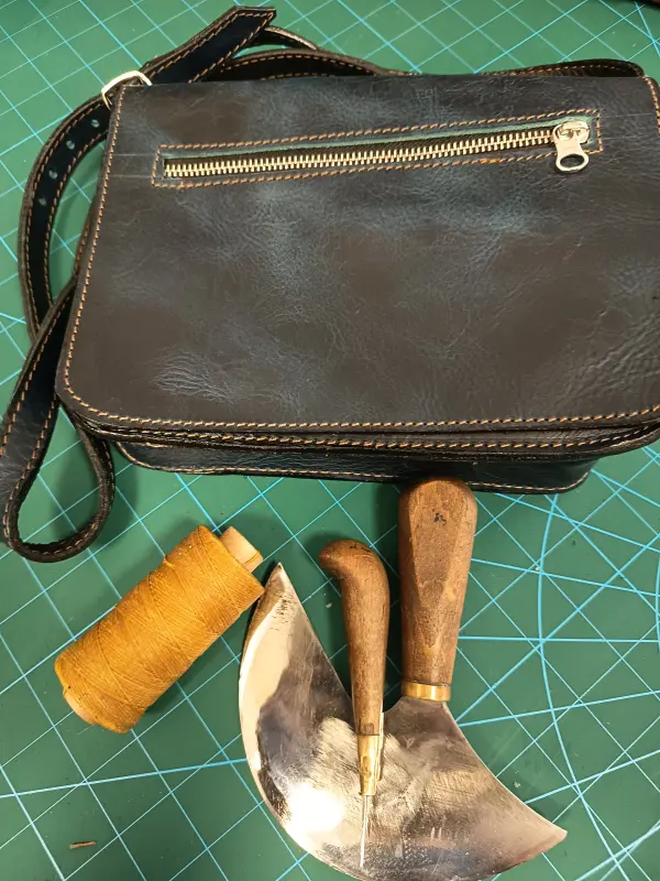 Tmavá kožená taška přes rameno se zipem a zdobným prošíváním