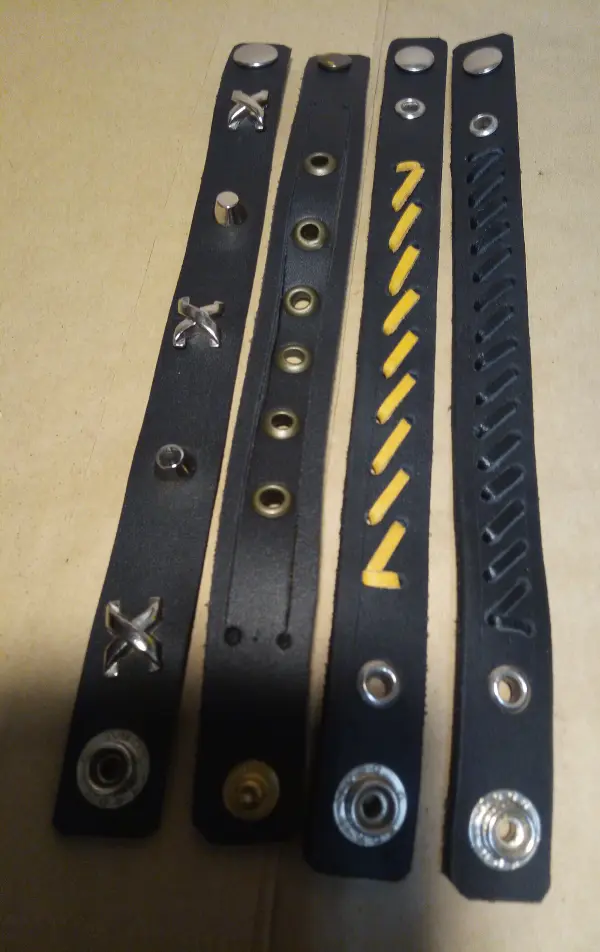 Detailní pohled na náramky se žlutým prošíváním a nýty