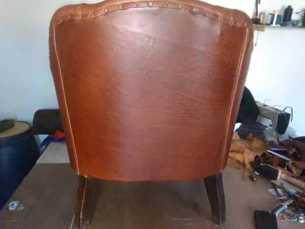 Zadní pohled na kožené křeslo s ozdobným pobitím hřeby