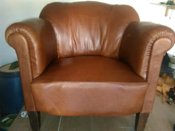 Čelní pohled na kožené polstrované křeslo v hnědé barvě